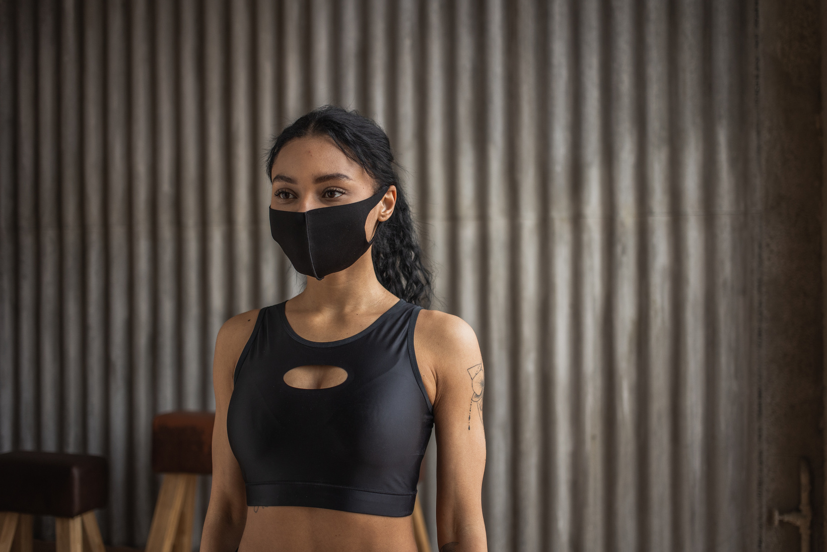 Black sportswoman in fabric mask in gym